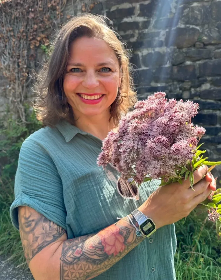 Caro, dipl. Kräuterfachfrau, mit frisch gesammelten Wildblumen
