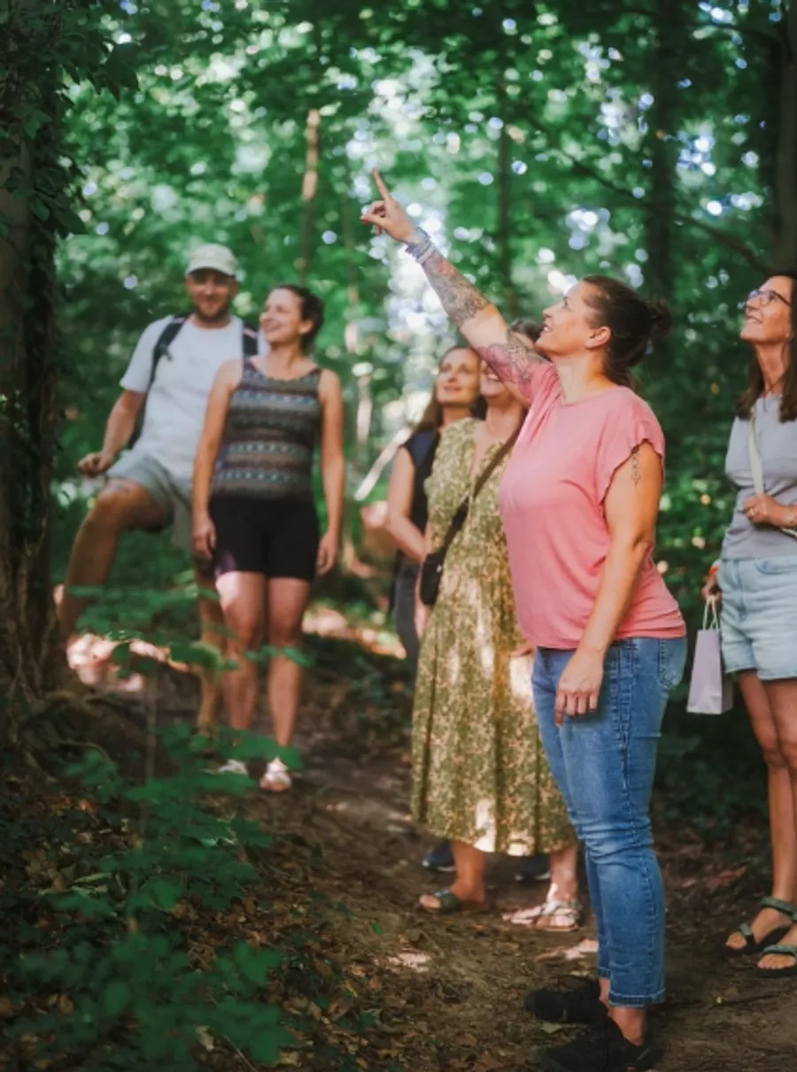Gruppe unterwegs durch den Wald, Caro zeigt nach oben